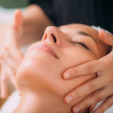 Woman Enjoying a Professional Ayurvedic Facial Massage with Therapeutic Essential Oils