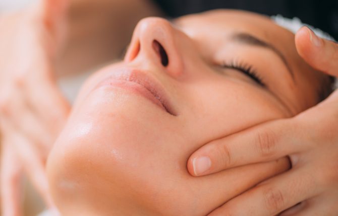 Woman Enjoying a Professional Ayurvedic Facial Massage with Therapeutic Essential Oils